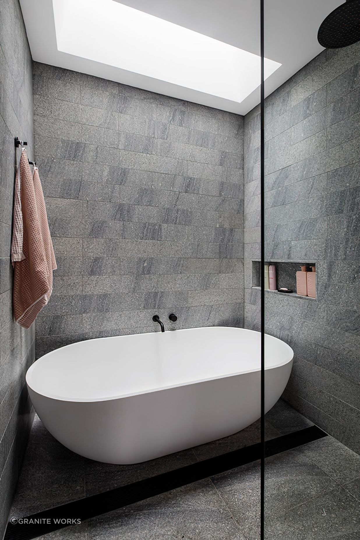 Aston grey granite tile surrounds the luxury white freestanding bath.