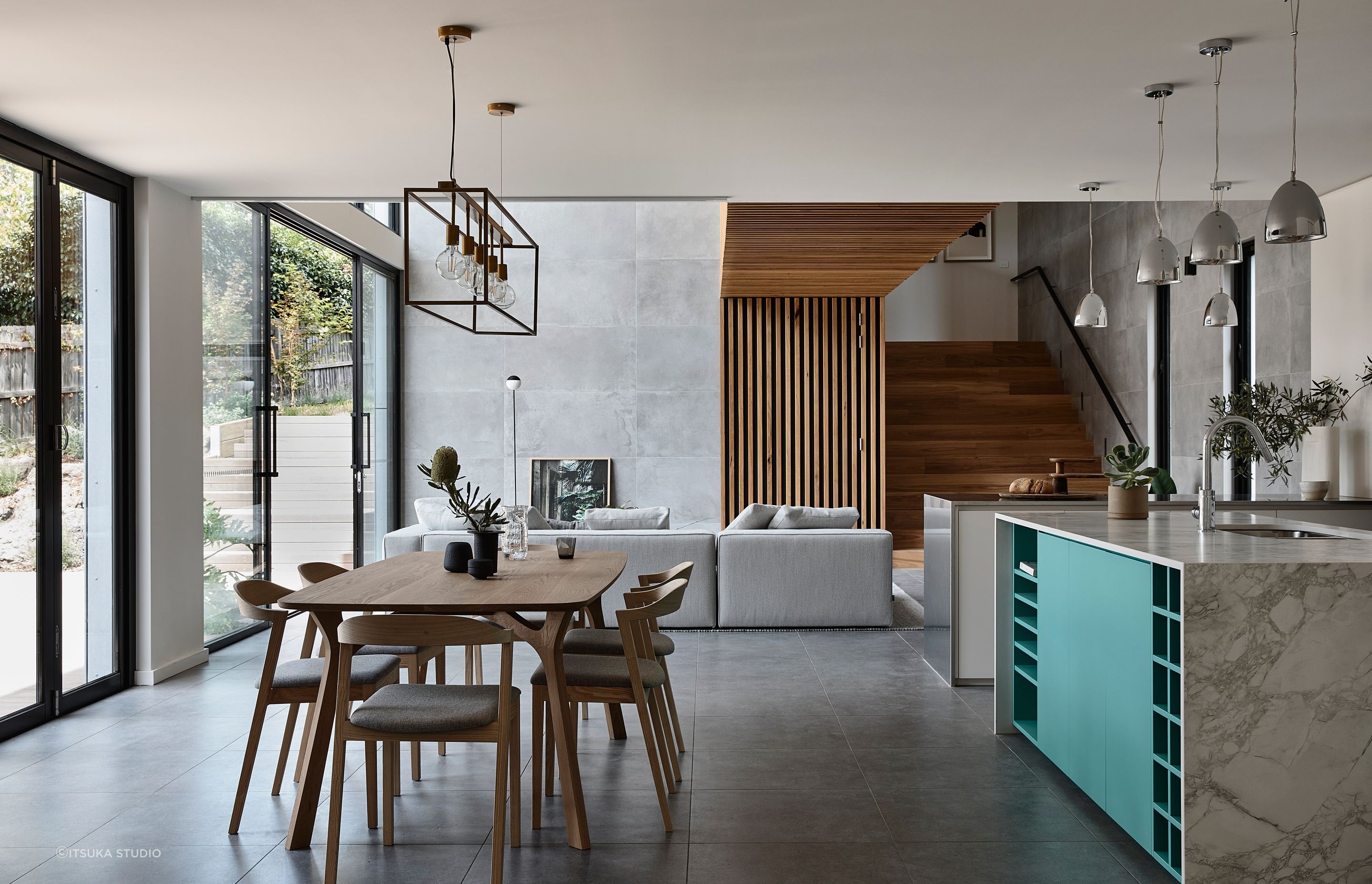 While the timber-clad link bridge is the feature of the double-height living area, a feature has also been made of the kitchen with its vibrant blue accents. 