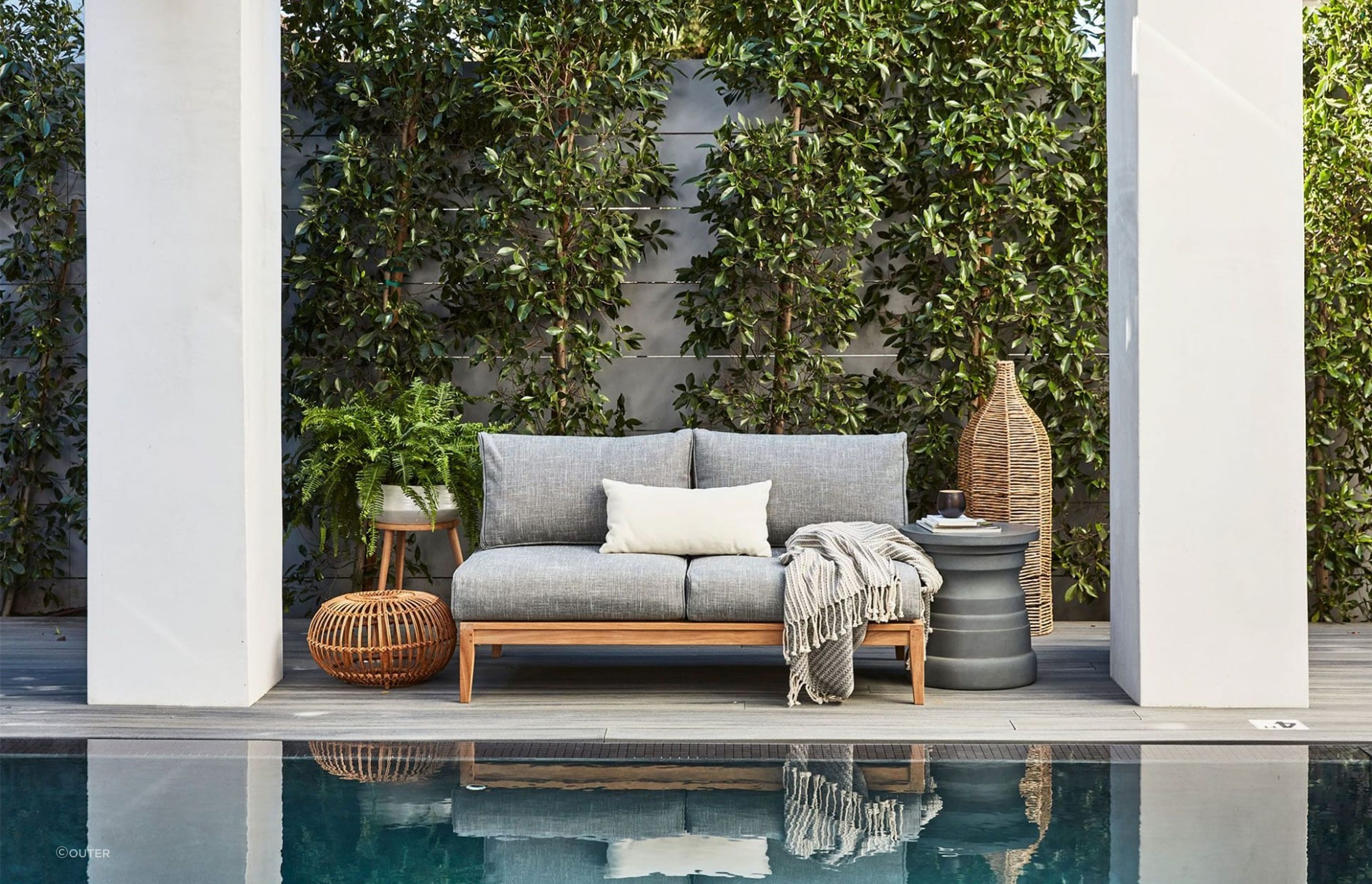 The plush Teak Outdoor Loveseat takes centre stage in a scene that completely embodies comfort
