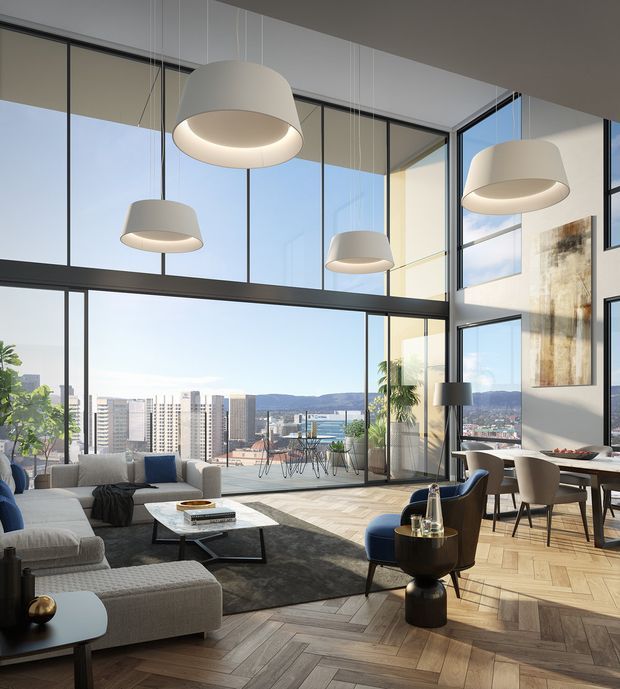 A bright, sophisticated double-height living and dining space with expansive black-framed floor-to-ceiling glazing overlooking a city skyline and distant hills. The room features pale herringbone timber flooring, a large light sectional sofa, dark area rug, marble-look coffee table, sculptural pendant lights, contemporary dining furniture, and a tall abstract wall artwork. A mezzanine-like upper level and dramatic glazed corner emphasize the spacious vertical volume.