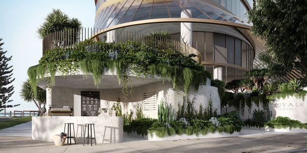 A high-end contemporary multi-storey building exterior with sweeping curved glazed forms, rounded balconies, and a projecting concrete terrace. Lush layered planting, hanging greenery, palms, and vertical timber screening soften the facade. An outdoor bar or entertaining counter with stools occupies the lower terrace, while a paved approach and landscaped entry are visible at ground level.