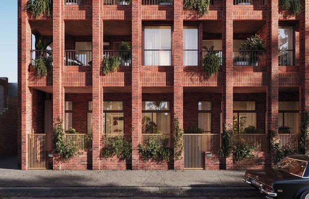 Street-level view of a multi-storey red-brick residential apartment building with a strongly repetitive facade. The facade features deep recessed balconies, projecting brick piers, dark metal balcony railings, timber-toned entry gates, and abundant greenery in planters. Ground-floor glazing and private entrances open directly onto the pavement, while a vintage car is partially visible at the curb.