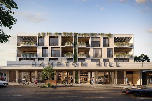 Architectural rendering of a contemporary multi-storey mixed-use building with ground-floor retail or commercial spaces and upper-level apartments. The facade uses a regular grid of recessed balconies, large windows, light neutral cladding, dark metal frames, and abundant integrated greenery. A broad podium or awning projects over the active street frontage, with pedestrians and bicycles shown along the sidewalk.