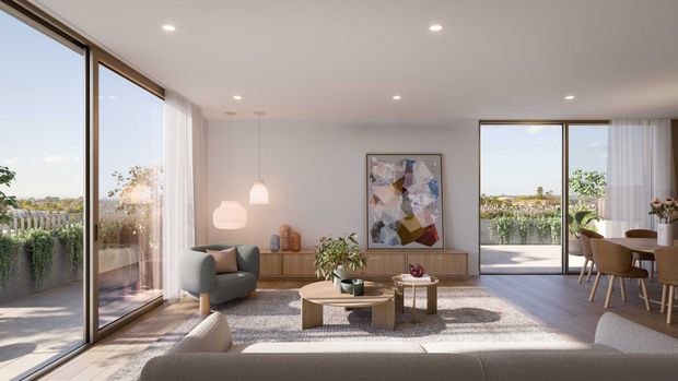 Bright contemporary open-plan living and dining area with expansive floor-to-ceiling glazing, sheer curtains, a neutral palette, timber cabinetry, sculptural pendant lights, a low round coffee table, and framed abstract artwork. The room opens to a planted balcony or terrace with distant suburban views.