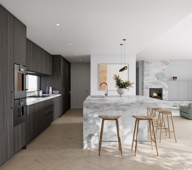 Contemporary open-plan kitchen and living area with dark timber cabinetry, integrated appliances, a large pale marble-look island with timber bar stools, and a fireplace set into a light stone feature wall. The space has light timber flooring, white walls and ceiling, pendant lighting, and a neutral refined palette.