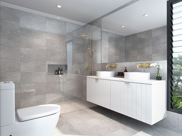 Contemporary bathroom with large-format grey stone-look wall and floor tiles, a frameless glass shower enclosure, wall-hung white vanity with twin vessel basins, brushed-gold tapware, recessed ceiling lights, a toilet, and louvred window glazing.