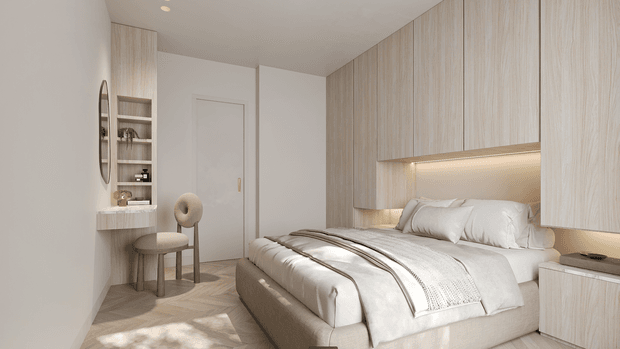 A compact, refined bedroom with a softly neutral palette. The room features a bed with layered white bedding, a full-height light timber-look built-in headboard and cabinetry wall, integrated warm under-cabinet lighting, a small built-in dressing nook with shelving and an oval mirror, and a pale timber herringbone floor. Minimal detailing and concealed storage create a calm, cohesive interior.