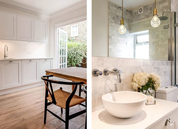 A split interior view showing a bright classic kitchen-dining area alongside a refined bathroom. The kitchen features pale panelled cabinetry, a timber floor, white benchtop and splashback, a timber dining table, and black-framed chairs beside glazed doors. The bathroom has marble-look wall finishes, a white vessel basin on a pale vanity, wall-mounted chrome tapware, a mirrored cabinet or wall, a toilet, and pendant lights.