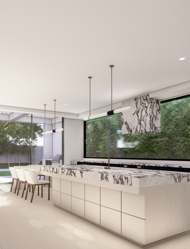 Bright contemporary kitchen with a large island, integrated pale cabinetry, dramatic veined stone benchtops and splashback, pendant lighting, and expansive glazing overlooking dense greenery. A dining area and outdoor pool or courtyard edge are visible beyond the kitchen.