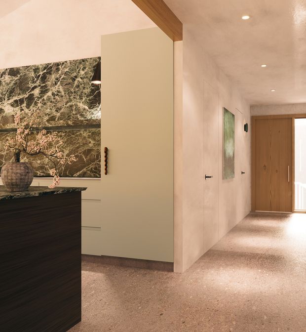 Warm, refined residential hallway and entry area with a terrazzo-style floor, smooth pale plaster walls, concealed or flush doors, a timber pivot entrance door, and a prominent dark marble feature wall beside dark built-in cabinetry. Timber ceiling beam detailing and recessed downlights add warmth and definition.