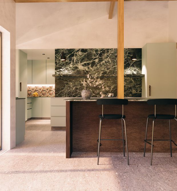 A warm, contemporary kitchen with a peninsula or island clad in dark timber, two black bar stools, pale green cabinetry, and a dramatic dark marble feature backsplash and benchtop. Terrazzo-like flooring, timber structural framing, soft plaster walls, and layered pendant lighting create a refined, earthy interior.