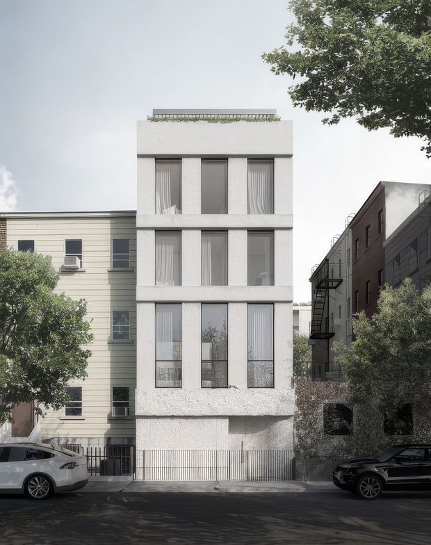 Street-facing view of a narrow, multi-storey contemporary urban residential building with a textured white facade, repetitive tall windows, a rooftop terrace or planted roof edge, and a gated ground-level frontage. Adjacent older and industrial-style buildings, street trees, and parked cars frame the property.