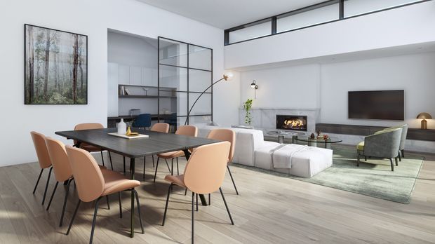 Open-plan contemporary living and dining area with a large dining table and peach upholstered chairs in the foreground, a pale sectional sofa and fireplace seating zone beyond, and a wall-mounted television. The room has light timber flooring, white walls, a black-framed glazed partition, high ceilings with clerestory glazing, minimalist furnishings, and a muted neutral palette.