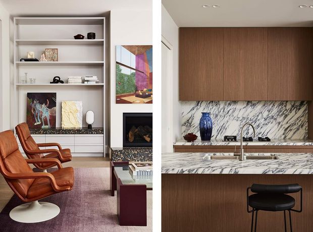 A split view of a refined open-plan interior. The left side shows a living room with built-in white shelving, artwork, a fireplace, leather lounge chairs, and a low coffee table. The right side shows a contemporary kitchen with dark timber cabinetry, a dramatic marble backsplash and island, and a black bar stool. The overall palette combines warm timber and leather with white and veined marble surfaces.