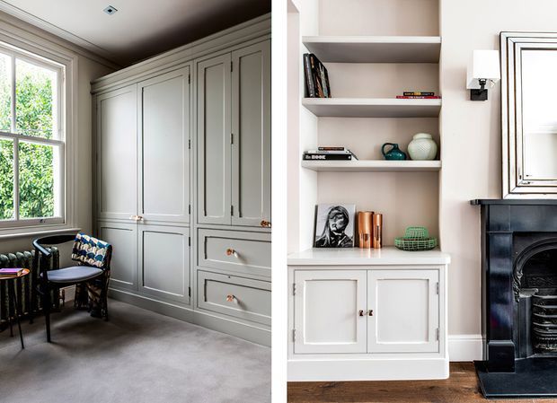 A refined traditional interior showing built-in pale grey cabinetry and wardrobes beside a window, with a small upholstered chair and radiator on the left. The adjoining view features open display shelving, lower storage cabinets, a framed wall detail, and a dark decorative fireplace surround. The room has muted neutral finishes, detailed panelled joinery, and classic proportions.