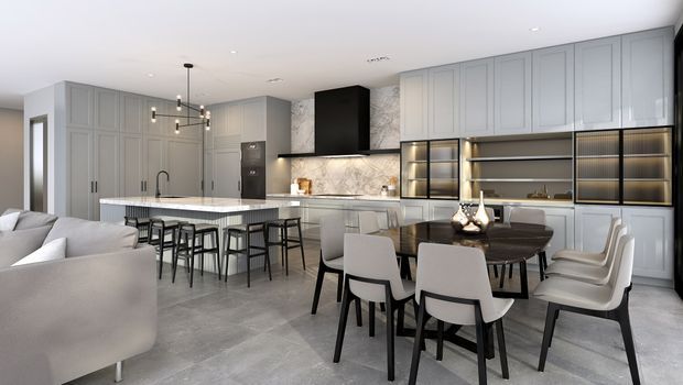A spacious open-plan kitchen and dining area with a contemporary grey palette. The kitchen features full-height framed cabinetry, a large island with seating, marble-look splashback, integrated appliances, and dark shelving with warm integrated lighting. A dining table and upholstered chairs sit beside the kitchen, while part of a living area is visible in the foreground. Large-format grey flooring and recessed ceiling lighting complete the refined interior.