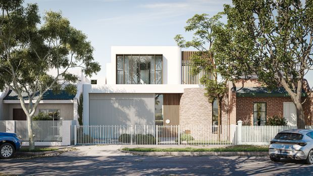 Street-facing view of a contemporary multi-level townhouse or residence with a crisp white rendered upper facade, extensive glazing, vertical metal screening, a pale brick-clad central section, and a darker brick adjoining facade. A white picket-style metal fence, landscaped verge, mature street trees, and parked cars frame the property.