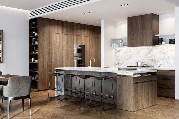 A refined open-plan kitchen with floor-to-ceiling dark timber cabinetry, integrated appliances, a large marble-look island with seating for four, and a matching stone splashback. Herringbone timber flooring, a built-in display shelf, recessed lighting, and linear ceiling ventilation contribute to the sleek, contemporary interior. A dining area is partially visible at left.