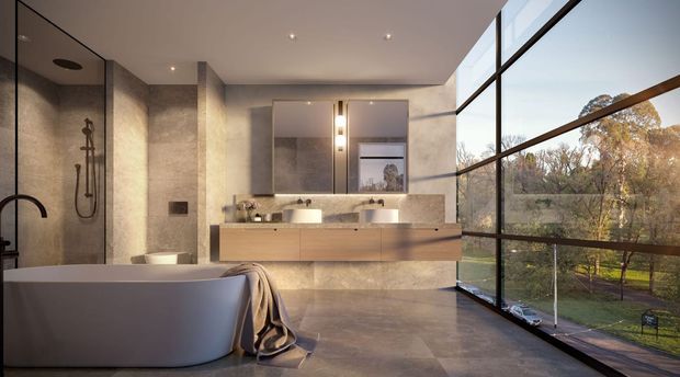 A luxurious contemporary bathroom with a freestanding sculptural bathtub in the foreground, a walk-in shower with dark fixtures to the left, and a long floating timber vanity with integrated basin and wall-mounted mirrors. Large floor-to-ceiling glazing provides views of landscaped grounds, while warm stone-look surfaces and concealed ceiling lighting create a refined, spa-like atmosphere.