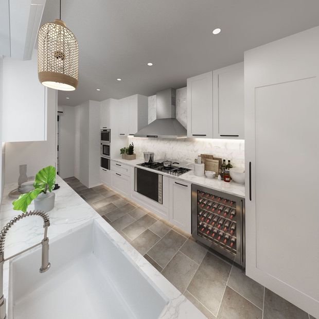 Bright contemporary kitchen with white shaker-style cabinetry, a large marble-look island and farmhouse sink, stainless-steel range hood and appliances, patterned light backsplash, and grey stone-look tiled flooring. A woven pendant light and indoor greenery add warmth, while a built-in wine cooler is integrated beneath the benchtop.