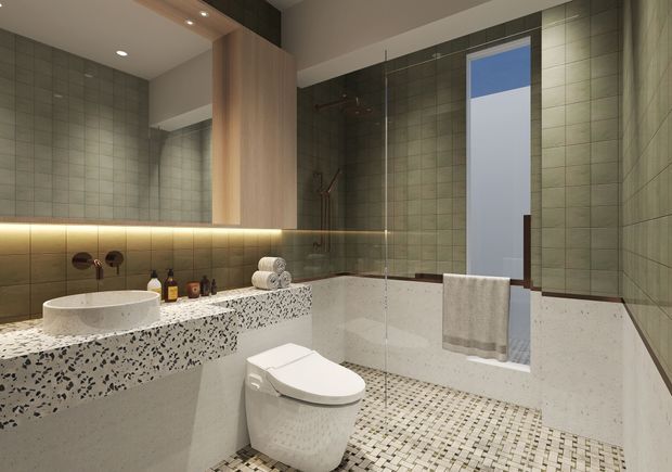 Contemporary bathroom with a freestanding oval basin on a terrazzo-style vanity, wall-mounted tapware, a concealed-cistern toilet, and a glazed shower or bath area. Small-format mosaic floor tiles, muted green-grey wall tiles, pale lower wall surfaces, timber-toned joinery, integrated shelf lighting, and a tall window create a refined, softly lit interior.