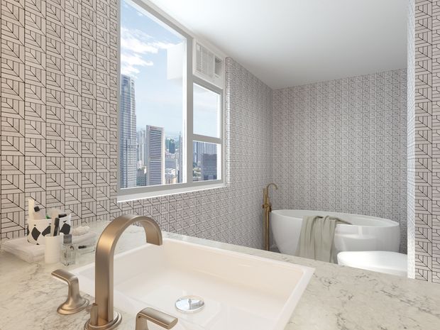 Bright contemporary bathroom with a freestanding bathtub, large vanity basin, brushed brass fixtures, pale marble-look benchtop, and full-height geometric patterned wall tiles. A large window provides city views and abundant natural light.