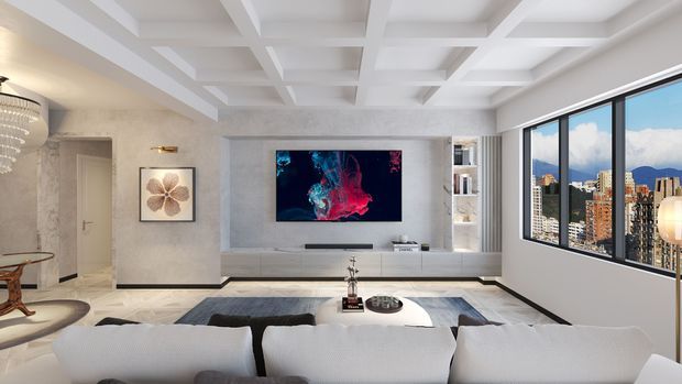 Bright, refined contemporary living room with a large white sectional sofa facing a wall-mounted television and low built-in media joinery. The room features a decorative coffered ceiling, light stone-look wall finishes, a sculptural chandelier, recessed shelving, and expansive corner glazing overlooking a dense city skyline and mountains. Neutral white, grey, and black finishes are accented by colourful abstract artwork.