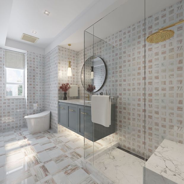 Bright contemporary bathroom with a frameless glass walk-in shower, rainfall showerhead, freestanding-style toilet, floating blue-grey vanity, round mirror, patterned wall and floor tiles, and a marble-look shower ledge. Natural light enters through a window, creating an airy, refined atmosphere.