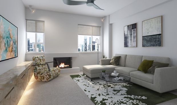 Bright contemporary living room with a large grey sectional sofa, patterned accent chairs, glass coffee table, abstract artwork, a built-in fireplace, and city views through two windows. A ceiling fan and neutral finishes complete the refined urban interior.