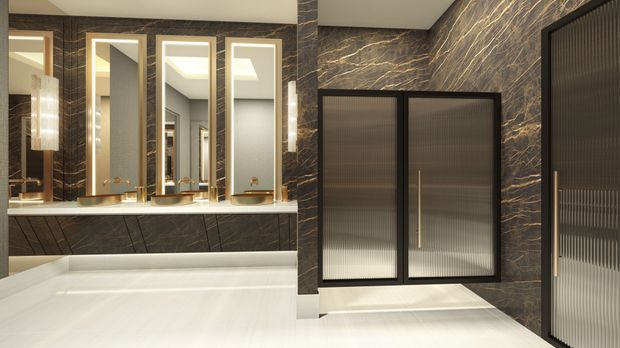 Luxurious contemporary bathroom featuring a freestanding white bathtub, dual vessel basins, tall mirrored medicine cabinets, dramatic dark veined stone wall finishes, and ribbed translucent-glass cabinetry or doors with warm metallic hardware. The space has a refined, hotel-like aesthetic with integrated lighting and a high-contrast neutral palette.