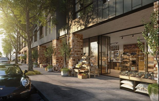 Street-level exterior view of a contemporary mixed-use retail building, with exposed brick columns, dark metal and glazed upper facade, and a shopfront opening onto the pavement. The storefront displays shelves, crates and packaged goods, while mature street trees, planters and a parked vintage car frame the scene.