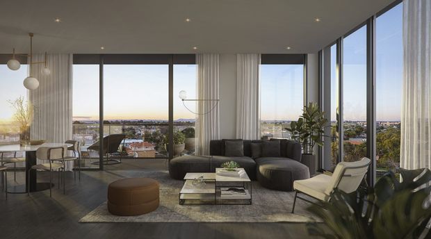 A spacious contemporary living room with floor-to-ceiling corner glazing and wide panoramic views over a suburban landscape. The room features a dark sectional sofa, sculptural lounge chairs, a glass coffee table, dining area, neutral curtains, indoor plants, and recessed ceiling lighting. The dark timber-toned floor and restrained furnishings create a refined, airy interior with strong indoor-outdoor visual connection.