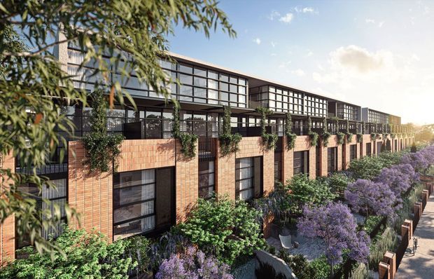 A contemporary multi-storey residential development viewed from an elevated angle, featuring long rows of warm brick facades, dark metal-framed glazing, projecting upper-level volumes, planted terraces and landscaped pedestrian paths with purple flowering shrubs. The repetitive stepped facade and extensive glazing create a modern urban townhouse or apartment-building character.