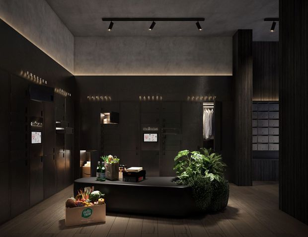 A dark, refined retail or showroom interior with matte black built-in cabinetry and display walls, a central dark island counter, indoor plants, timber-look flooring, and a textured concrete ceiling and upper walls. Linear LED lighting washes the walls, while black track lighting provides focused illumination. Product or brand labels are visible on the cabinetry, suggesting a boutique commercial display space.