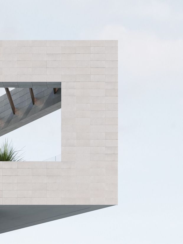 Minimalist architectural exterior detail showing a pale tiled or masonry-clad rectangular volume with a large square opening. A projecting dark grey roof or slab intersects the opening, with visible timber structural supports and a small planted element. The composition is highly geometric against a bright overcast sky.