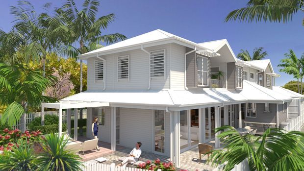 Bright exterior view of a large white multi-level tropical residence, featuring layered pitched roof forms, extensive louvred and glazed windows, covered verandas, balconies, and white weatherboard cladding surrounded by lush palms and landscaped planting.