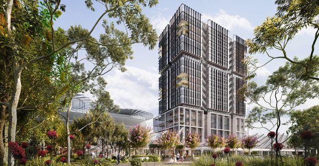 Architectural rendering of a contemporary multi-storey commercial or mixed-use building set within a landscaped urban campus. The tower has a stacked, rectilinear form with extensive floor-to-ceiling glazing, dark vertical metal screening, projecting balconies or planted terraces, and a glazed lower level. Mature trees, gardens, pedestrian paths, and a large low-profile roofed structure surround the building.