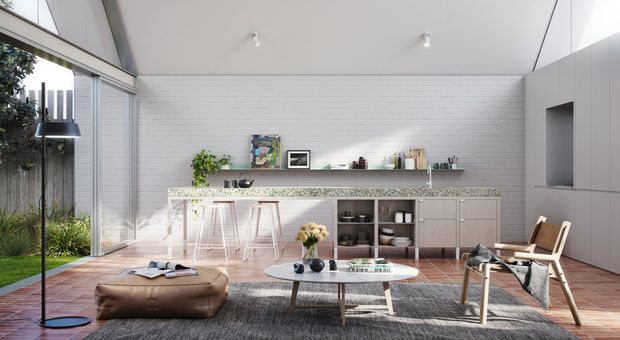 Bright open-plan contemporary living and kitchen space with a long linear kitchen, island bench with bar stools, integrated cabinetry, open shelving, and a relaxed seating area. Full-height glazing connects the room to a planted outdoor area. White horizontal wall panelling, pale cabinetry, warm timber flooring, and restrained furnishings create an airy, refined interior.
