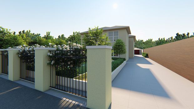 A rendered exterior view of a contemporary multi-level residence approached via a wide pale paved driveway. The property is enclosed by light rendered masonry pillars, black metal fencing, and flowering greenery, with a tall horizontal timber-toned privacy wall along one side. The home has a restrained pitched roof, large upper-level glazing, and landscaped garden edges.