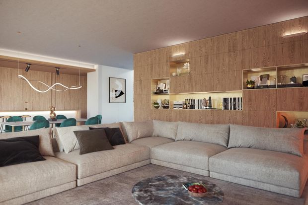 Open-plan contemporary living and dining area featuring a large L-shaped sectional sofa, built-in timber wall cabinetry with illuminated display niches and shelving, a dining table with teal chairs, and sculptural pendant lighting. The palette is warm and neutral with wood, beige upholstery, and dark accent cushions.