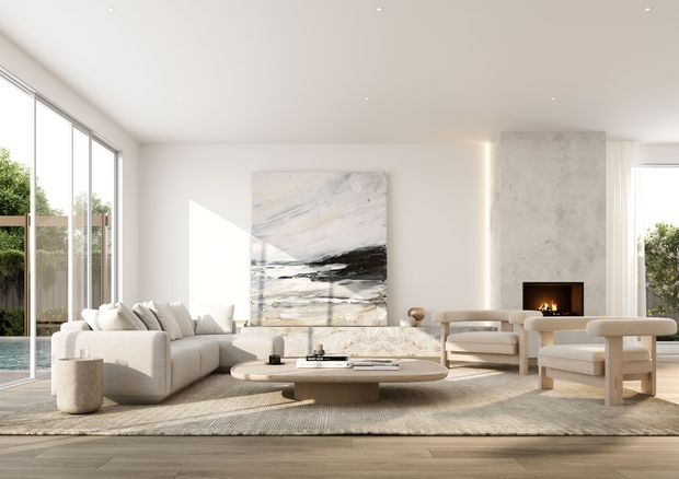 Bright, refined contemporary living room with a large pale sectional sofa, sculptural coffee table, neutral upholstered lounge chairs, textured area rug, and a minimalist fireplace set into a pale stone or plaster feature wall. Floor-to-ceiling glazing opens toward greenery and a pool or outdoor area, while an abstract artwork provides a restrained dark accent. The room has a spacious, airy feel with warm neutral finishes and abundant natural light.