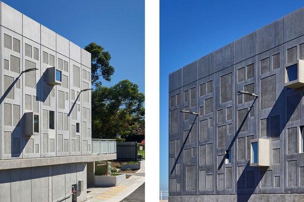 Diptych showing two views of a contemporary multi-storey concrete building facade. The elevations feature repetitive recessed rectangular panels, narrow windows, projecting box-like elements, and angled exterior light fixtures. The left view includes a paved access area and fencing, while the right view emphasizes the darker textured concrete facade against a clear blue sky.
