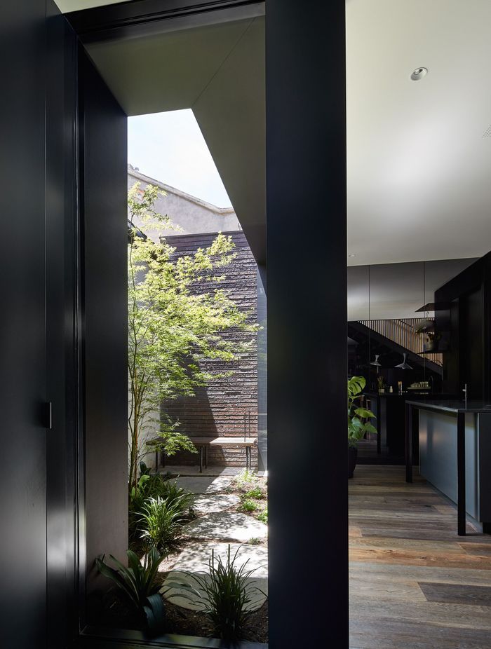 The ground floor addition embraces a bold aesthetic – all grey-tinted mirrors and dark walls, expanding the interior visually while cleverly disguising the compactness of the property.