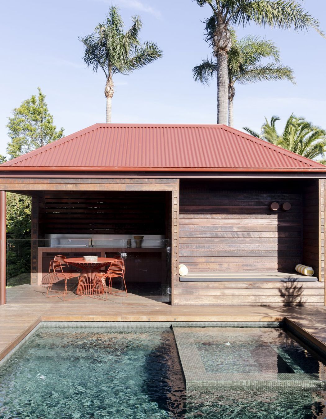 An outdoor entertainment space draws one toward cooling waters.