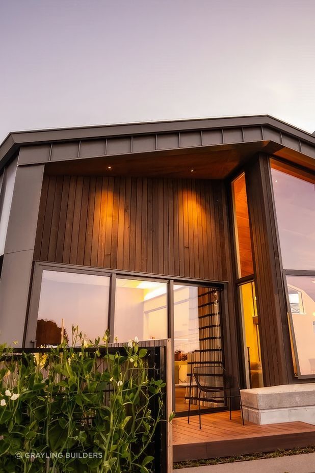 The facade features cedar cladding and aluminium standing seam roofing.