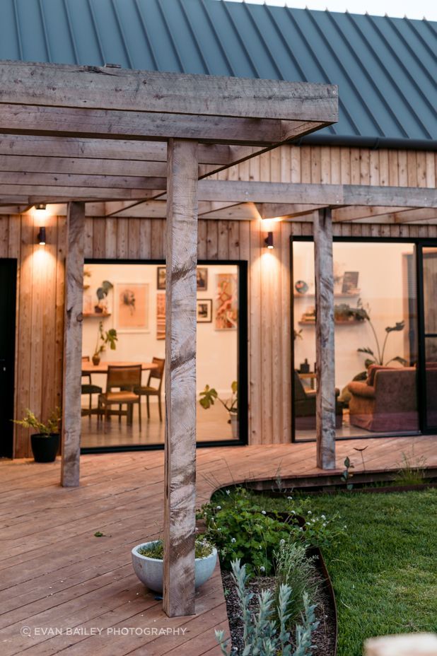 Large black framed windows connect the living zones to the outdoors.