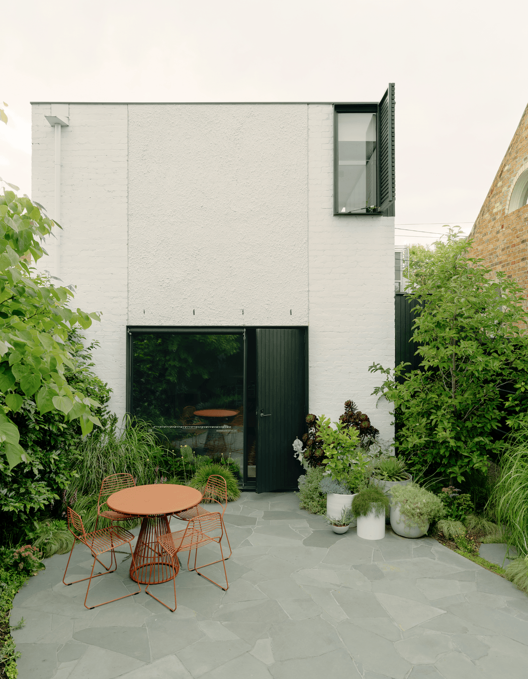 The green theme spills out into a light-filled courtyard abundant with greenery.
