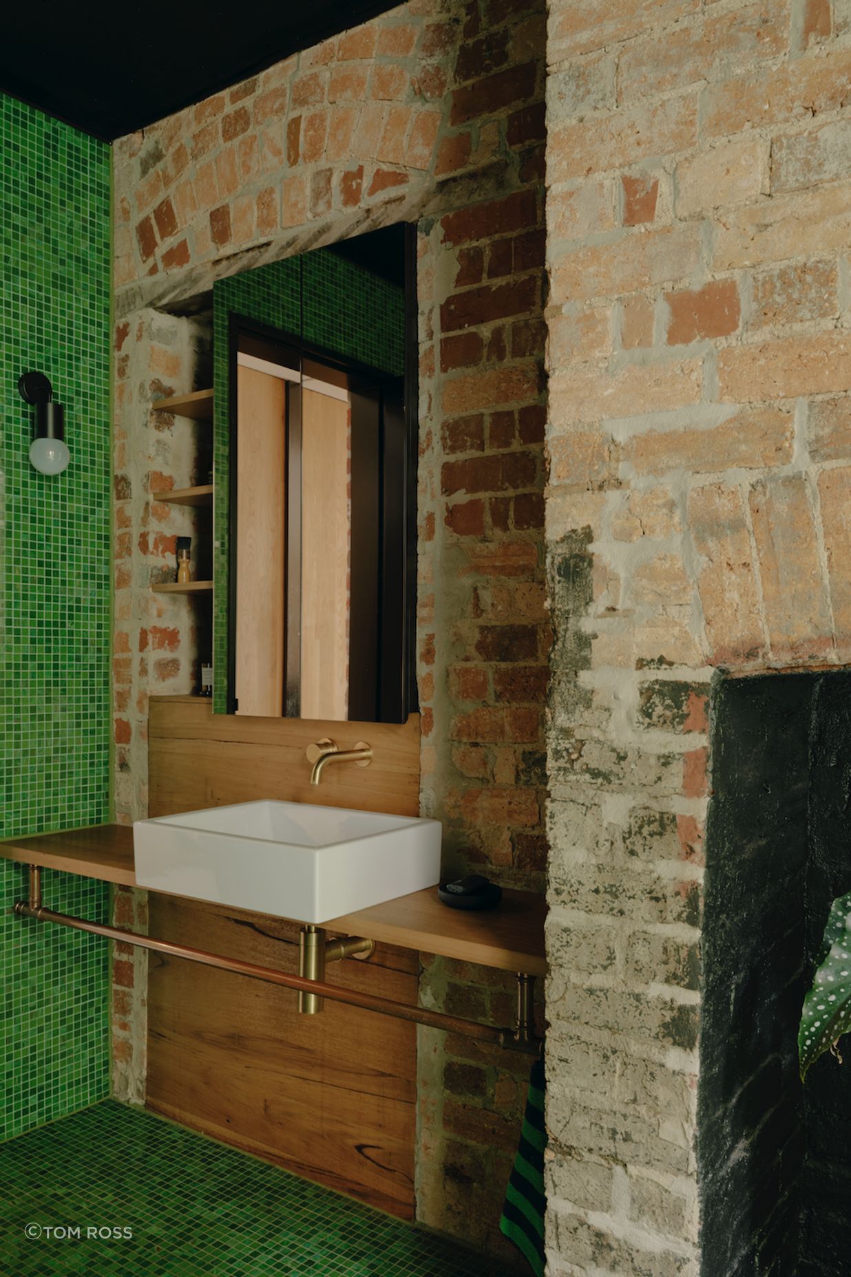 One element of the space is a particularly noteworthy design choice – a verdant green-tiled bathroom.