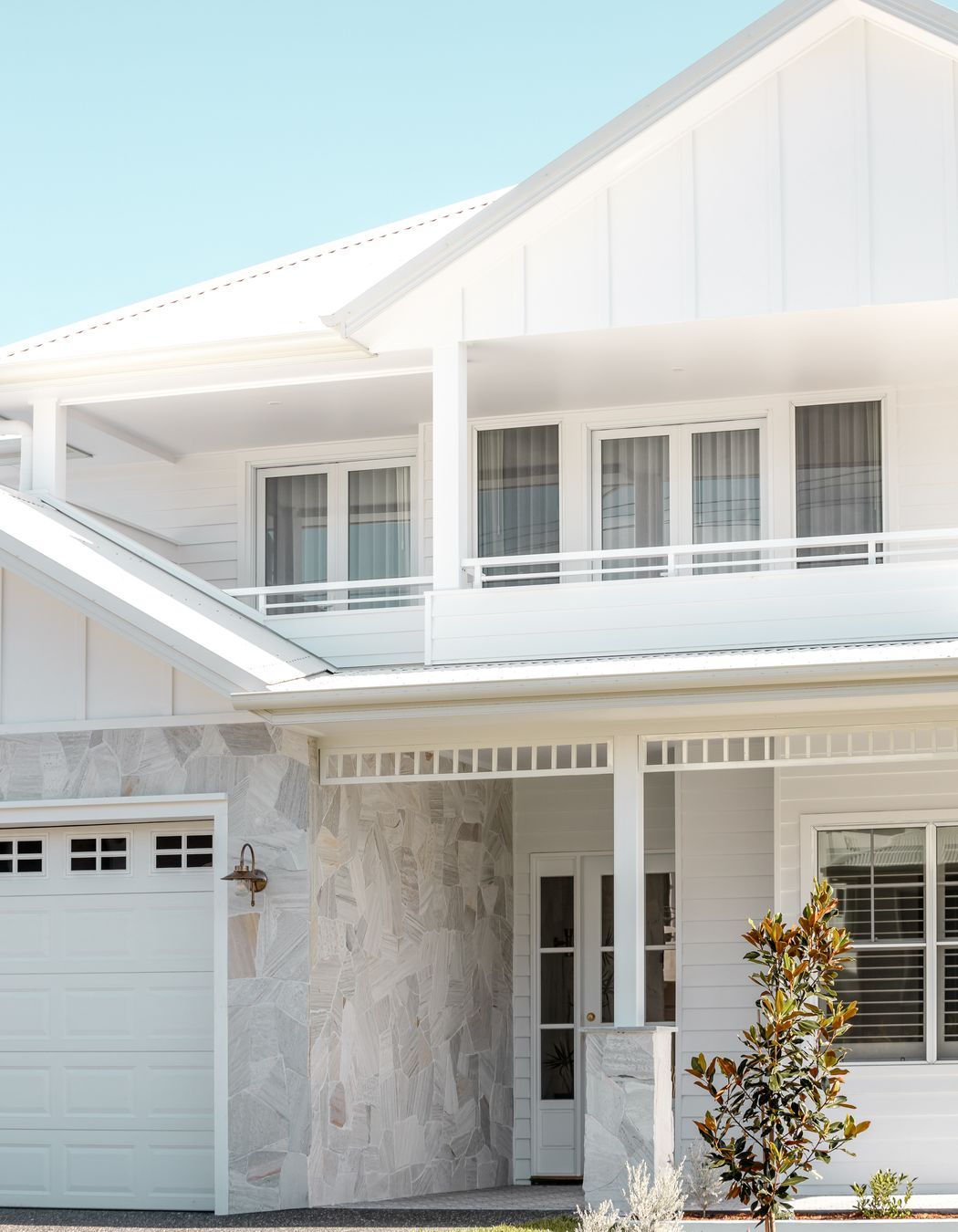 Natural stone breaks the all-white façade, reflecting the surrounding sand dunes.