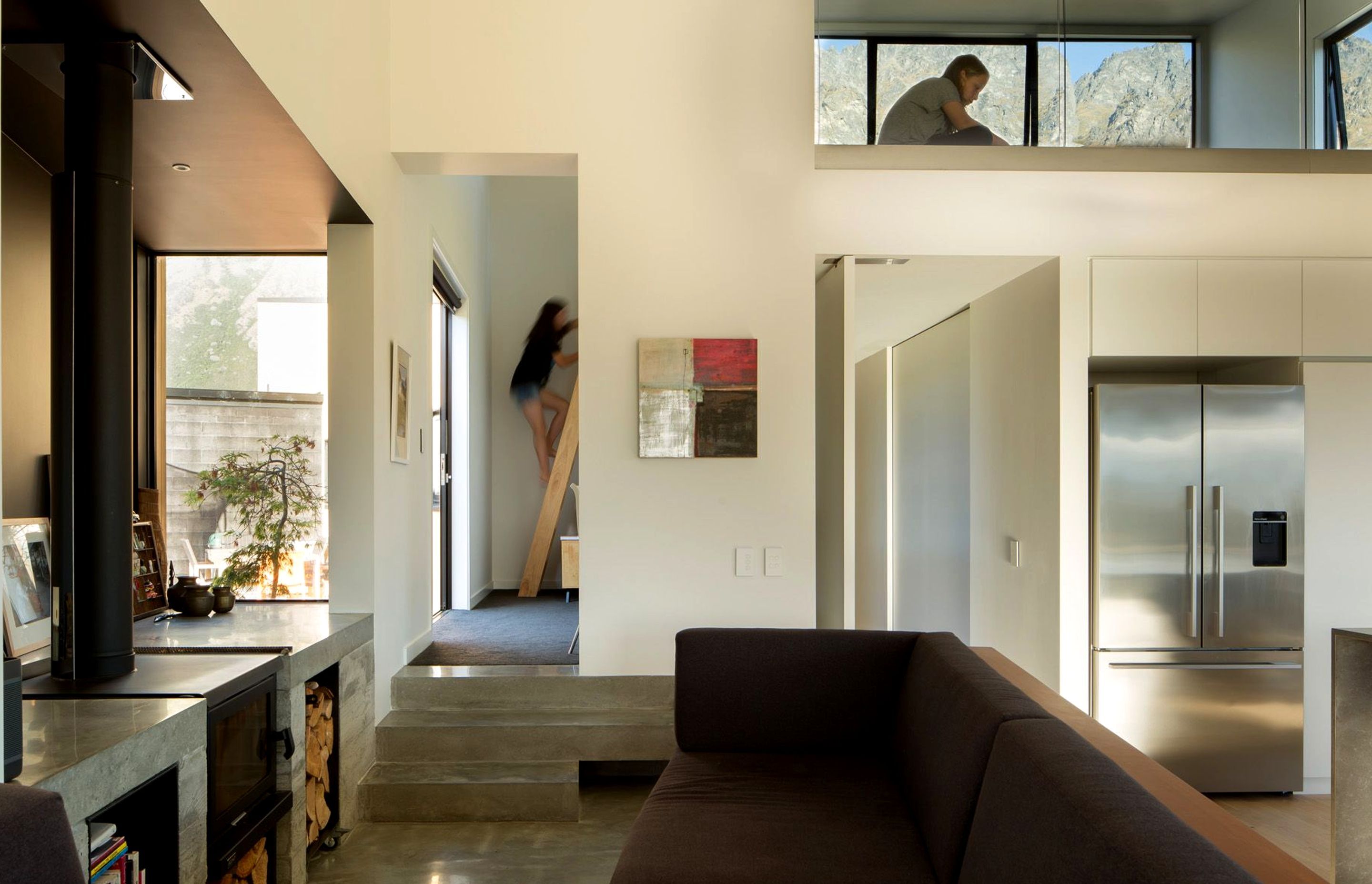 High windows draw sunlight into the mezzanine space and  through into the main living area. 